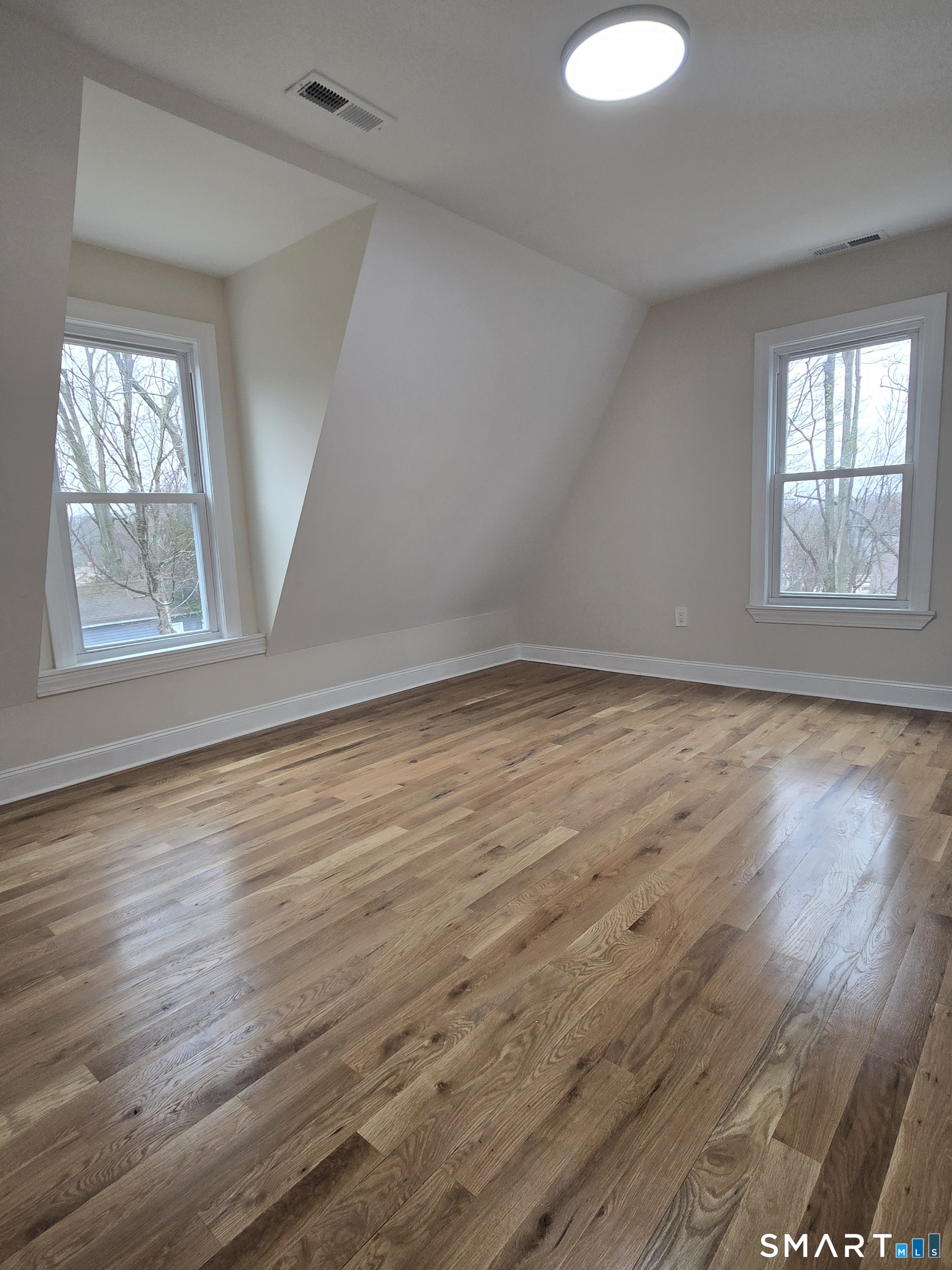 8 Pine Street Norwich, CT 06360 - Photo 19 of 27 an empty room with wooden floor and windows