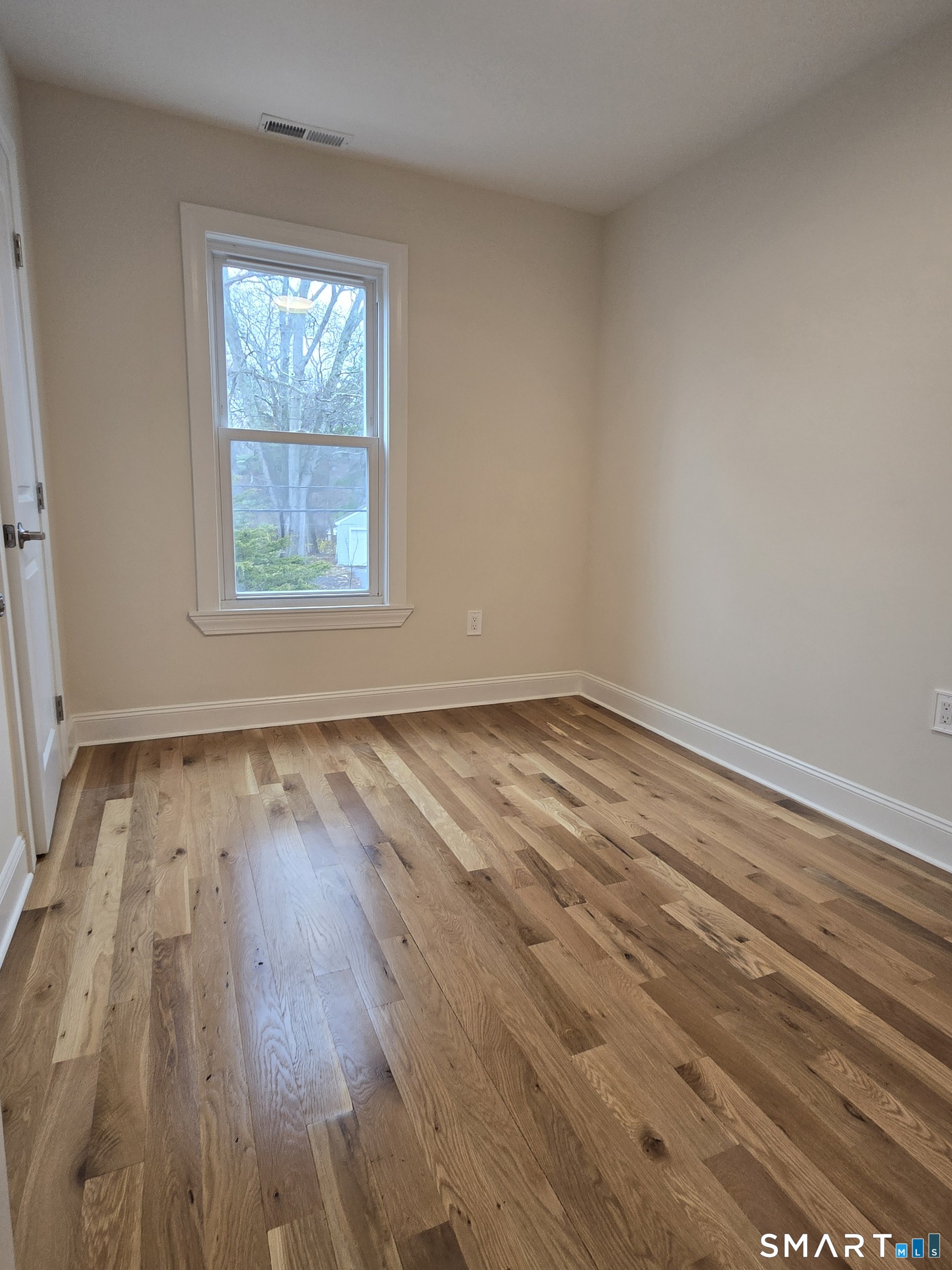 8 Pine Street Norwich, CT 06360 - Photo 23 of 27 an empty room with wooden floor and windows