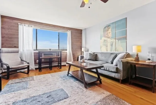 a living room with furniture and a dining table next to a window