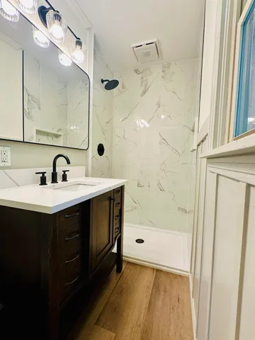a bathroom with a sink a mirror and a shower