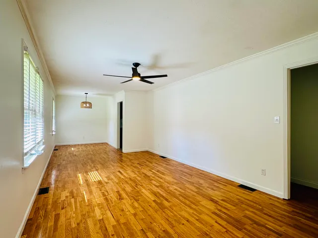 a view of empty room with wooden floor