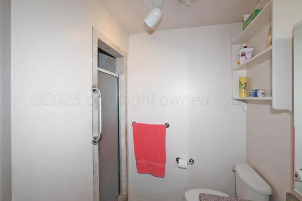 a bathroom with a toilet and a shower