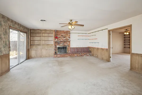 en empty room with windows and ceiling fan