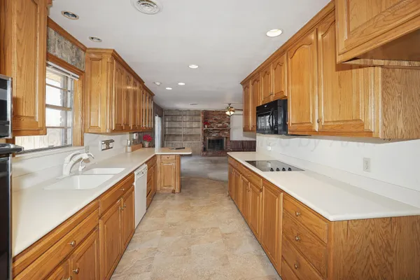a large kitchen with stainless steel appliances granite countertop a sink a stove and a refrigerator
