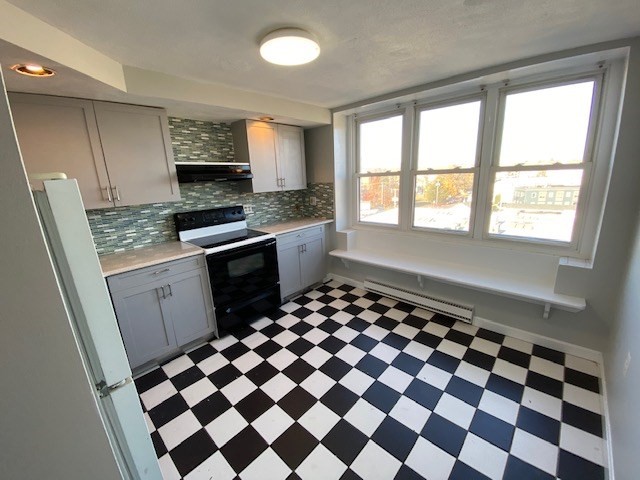 340 Main Street, Unit 501 Melrose, MA 02176 - Photo 6 of 11 a kitchen with a checkered floor and white cabinets