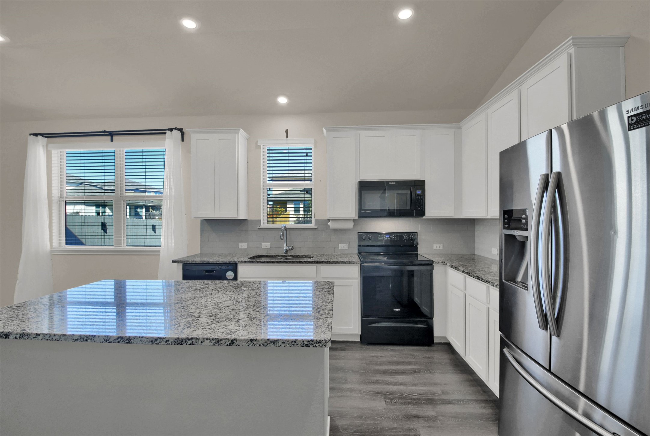 19032 Quebrada Drive Pflugerville, TX 78660 - Photo 9 of 29 Kitchen featuring black appliances, white cabinets, light stone counters, dark wood-style flooring, and recessed lighting