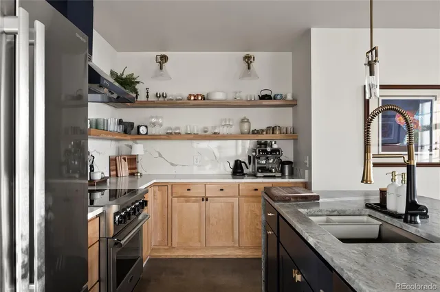 a kitchen with stainless steel appliances granite countertop a sink a stove and a refrigerator