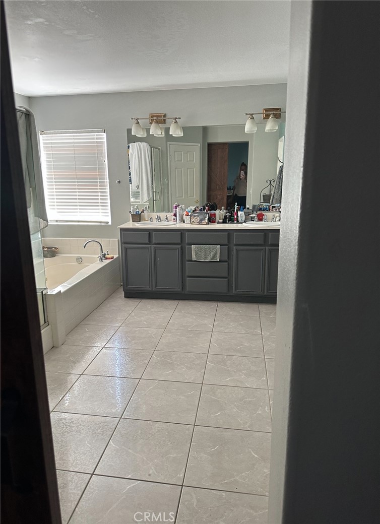 4300 Cloudywing Road Hemet, CA 92545 - Photo 20 of 29 a large bathroom with a tub a sink a mirror and a shower
