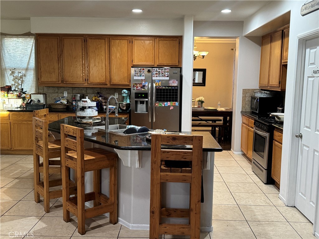 4300 Cloudywing Road Hemet, CA 92545 - Photo 7 of 29 a kitchen with stainless steel appliances a stove a sink a microwave and a refrigerator
