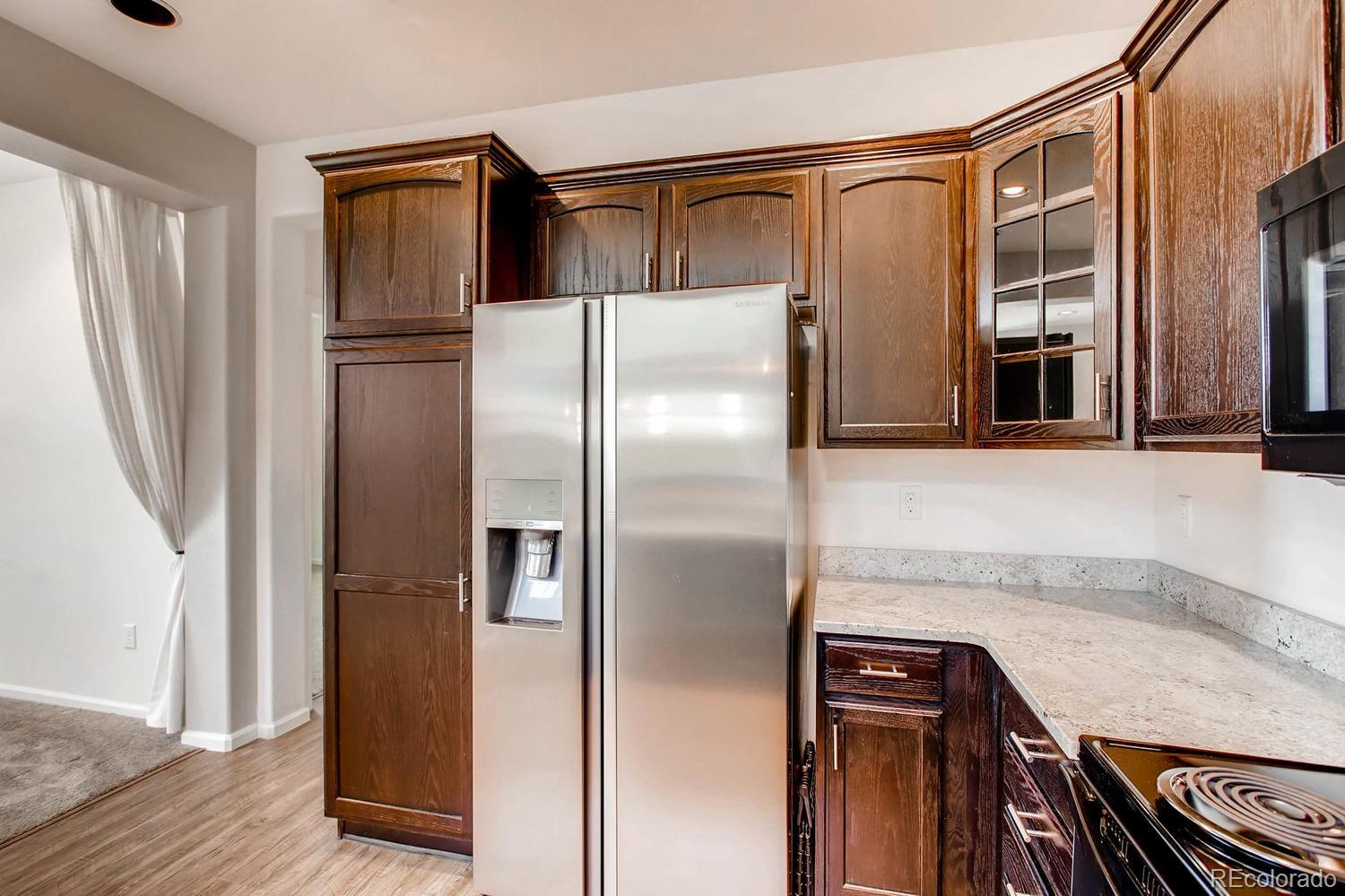 9511 Loggia Street, Unit C Highlands Ranch, CO 80126 - Photo 13 of 32 a kitchen with stainless steel appliances granite countertop a refrigerator and a sink