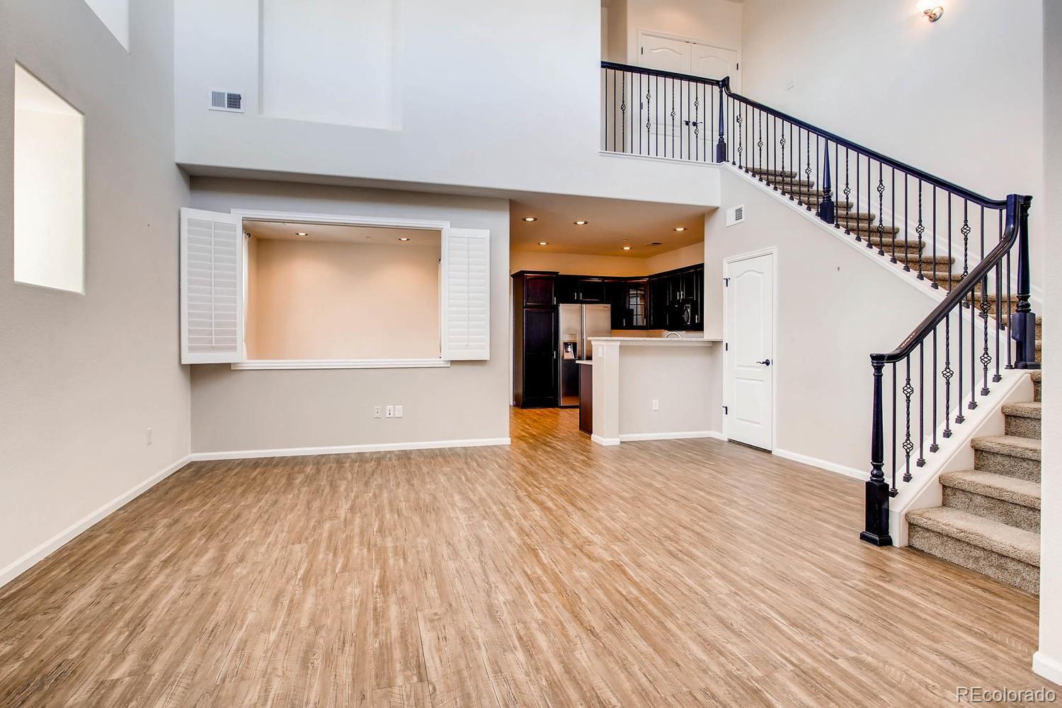 9511 Loggia Street, Unit C Highlands Ranch, CO 80126 - Photo 4 of 32 a view of a hallway with wooden floor and staircase