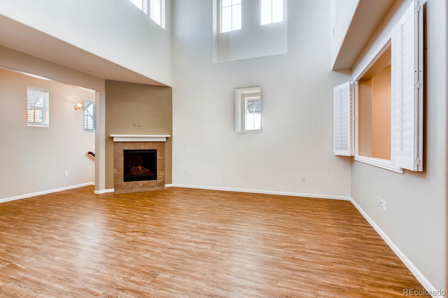 9511 Loggia Street, Unit C Highlands Ranch, CO 80126 - Photo 5 of 32 a view of empty room with wooden floor and fireplace
