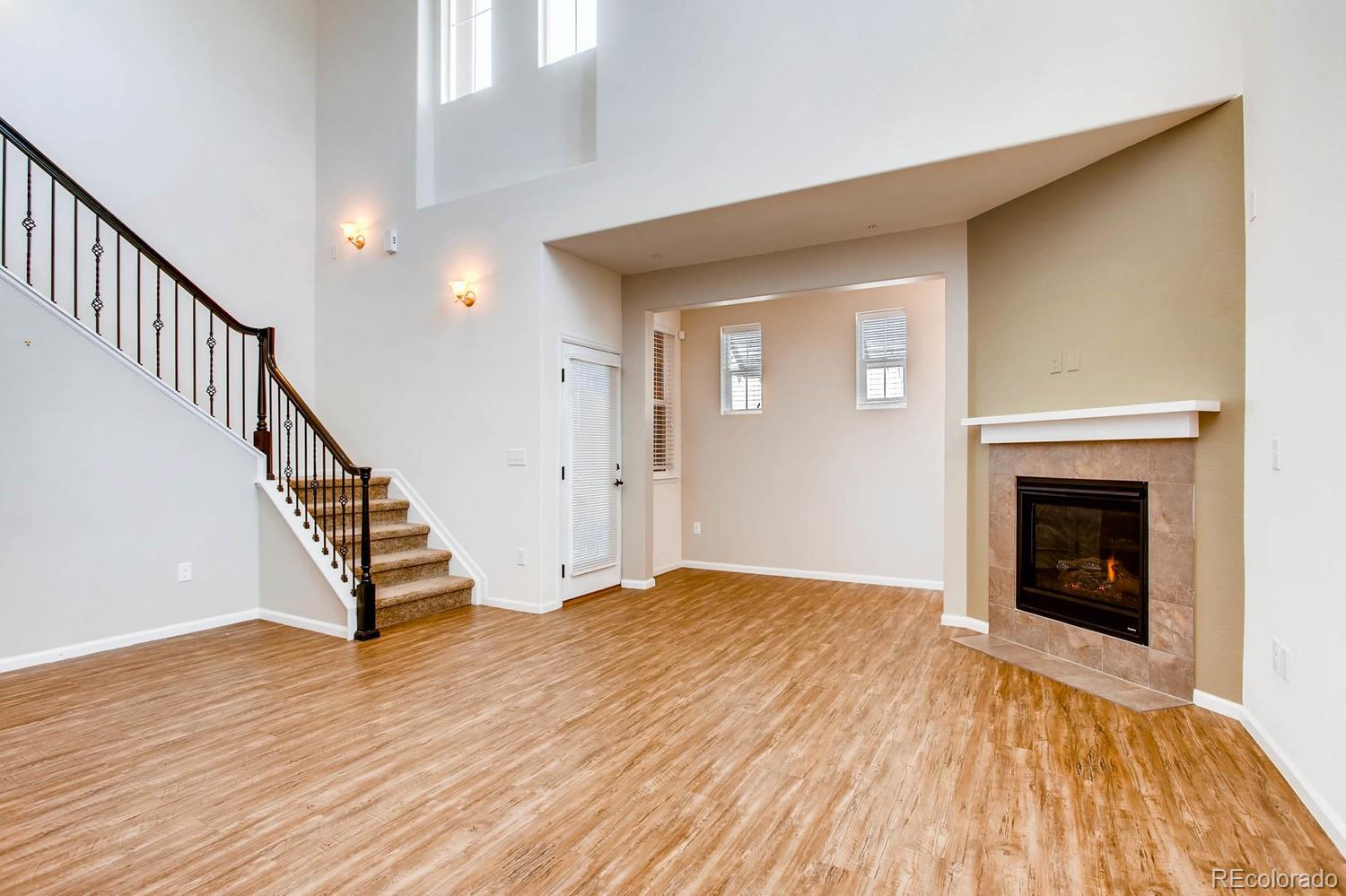 9511 Loggia Street, Unit C Highlands Ranch, CO 80126 - Photo 6 of 32 a view of an empty room with wooden floor fireplace and a window