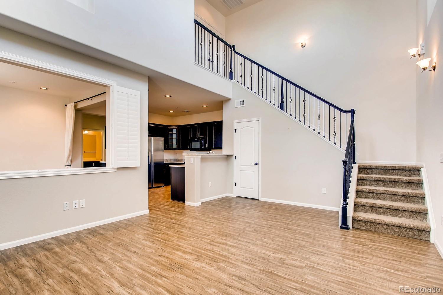 9511 Loggia Street, Unit C Highlands Ranch, CO 80126 - Photo 7 of 32 a view of a hallway with wooden floor and a kitchen view