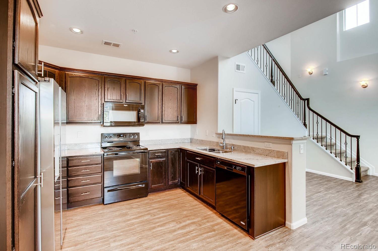 9511 Loggia Street, Unit C Highlands Ranch, CO 80126 - Photo 10 of 32 a kitchen with stainless steel appliances granite countertop a stove a sink and a refrigerator