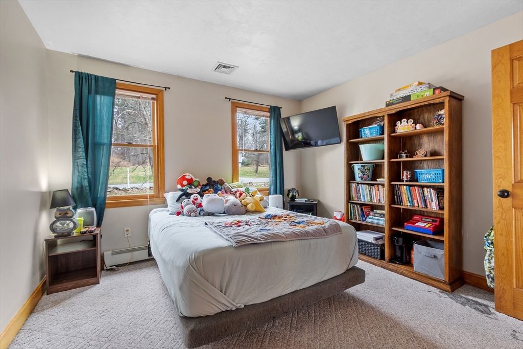 76 Woobly Road Bolton, MA 01740 - Photo 17 of 27 a bedroom with bed and a book shelf