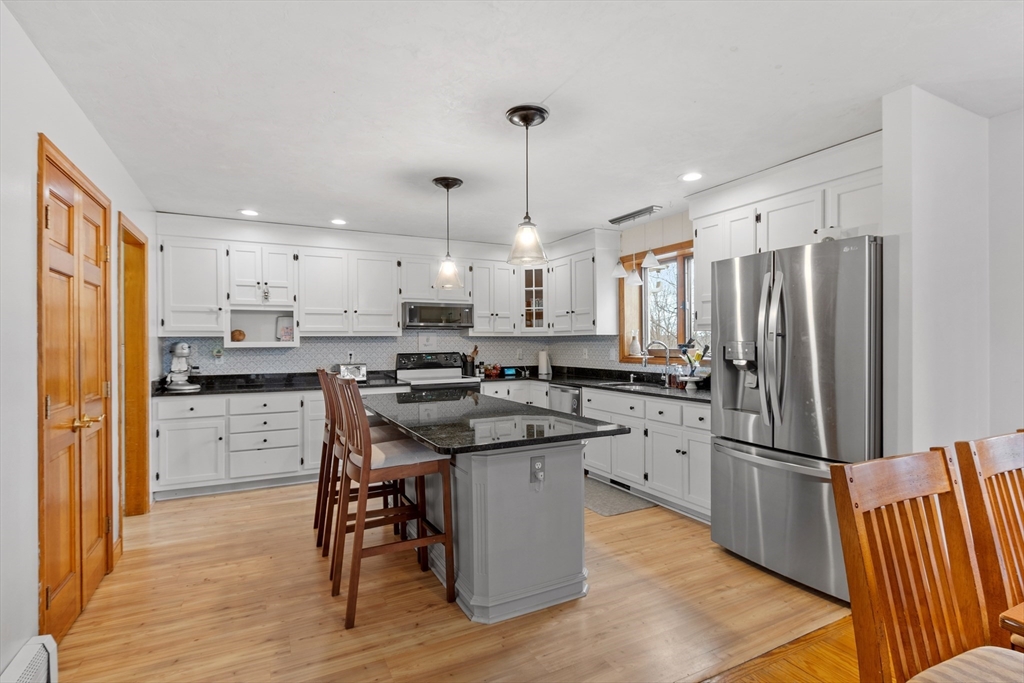 76 Woobly Road Bolton, MA 01740 - Photo 6 of 27 a kitchen with stainless steel appliances a refrigerator a sink dishwasher a stove and white cabinets with wooden floor