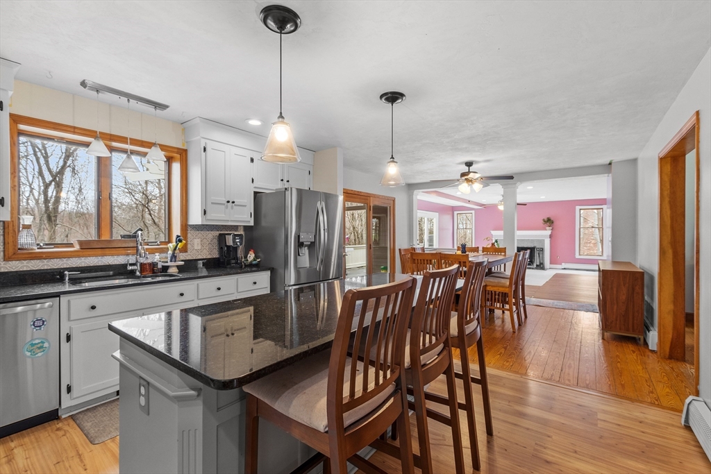 76 Woobly Road Bolton, MA 01740 - Photo 7 of 27 a kitchen with stainless steel appliances a dining table chairs stove and refrigerator