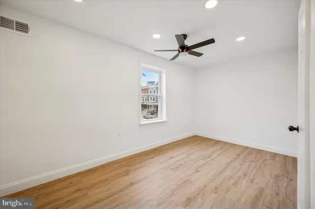 a view of a livingroom with wooden floor and a ceiling fan