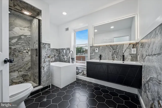 a bathroom with a sink toilet mirror and shower
