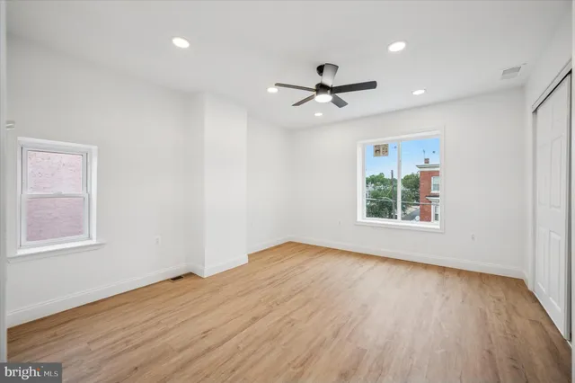 an empty room with wooden floor a ceiling fan and closet