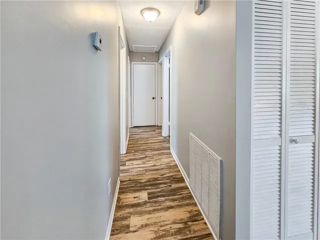 a view of a hallway with wooden floor and staircase