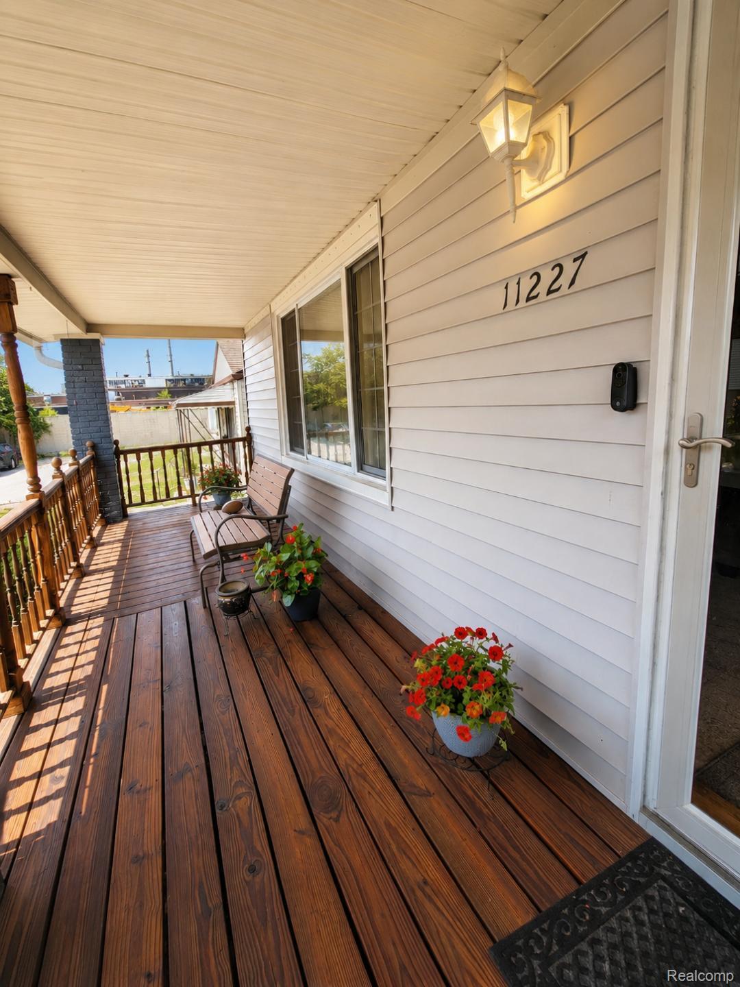 11227 Rivard Avenue Warren, MI 48089 - Photo 8 of 44 Covered front porch featuring rich wood-finish decking, white siding, and wood railings