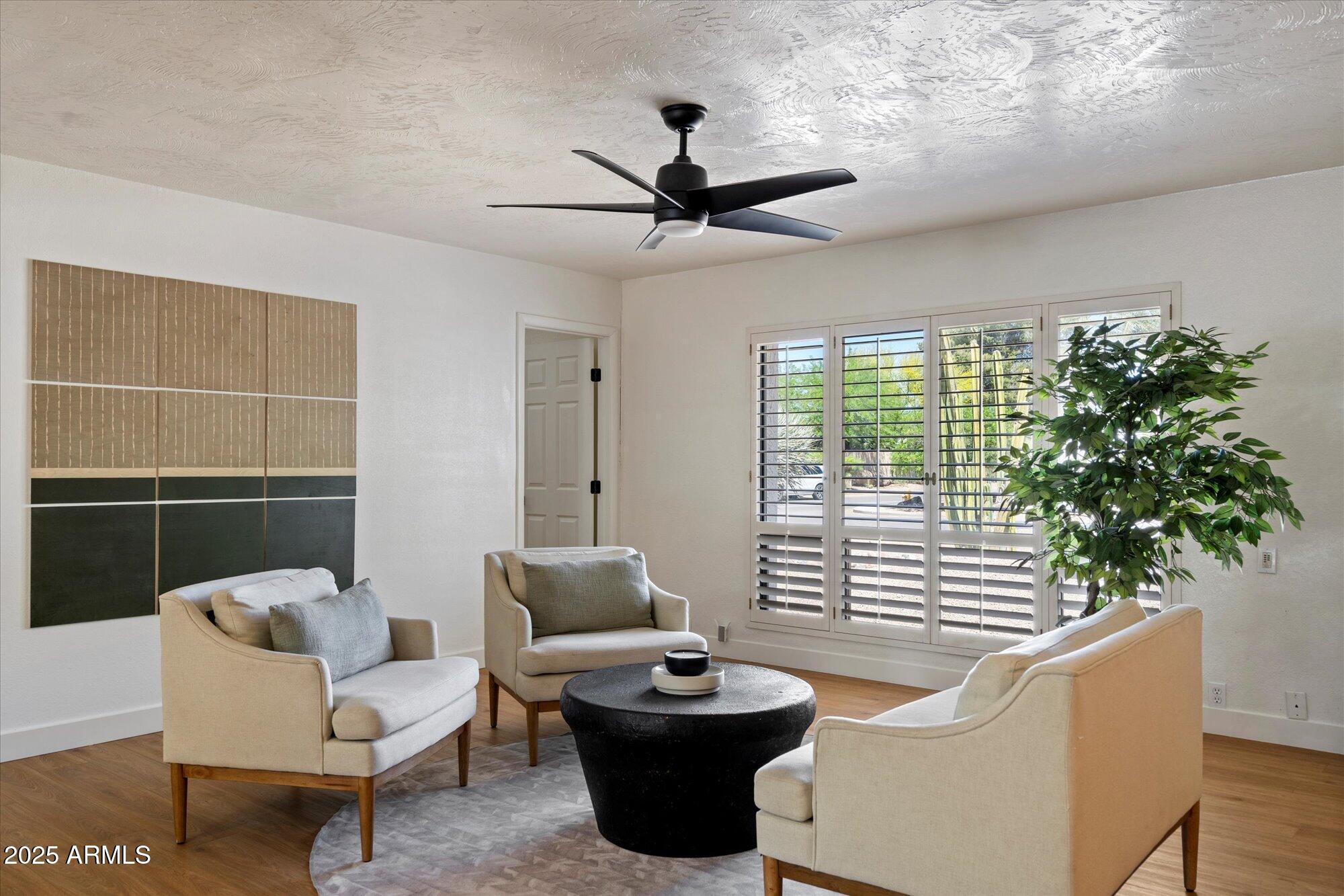 a living room with patio furniture and a potted plant