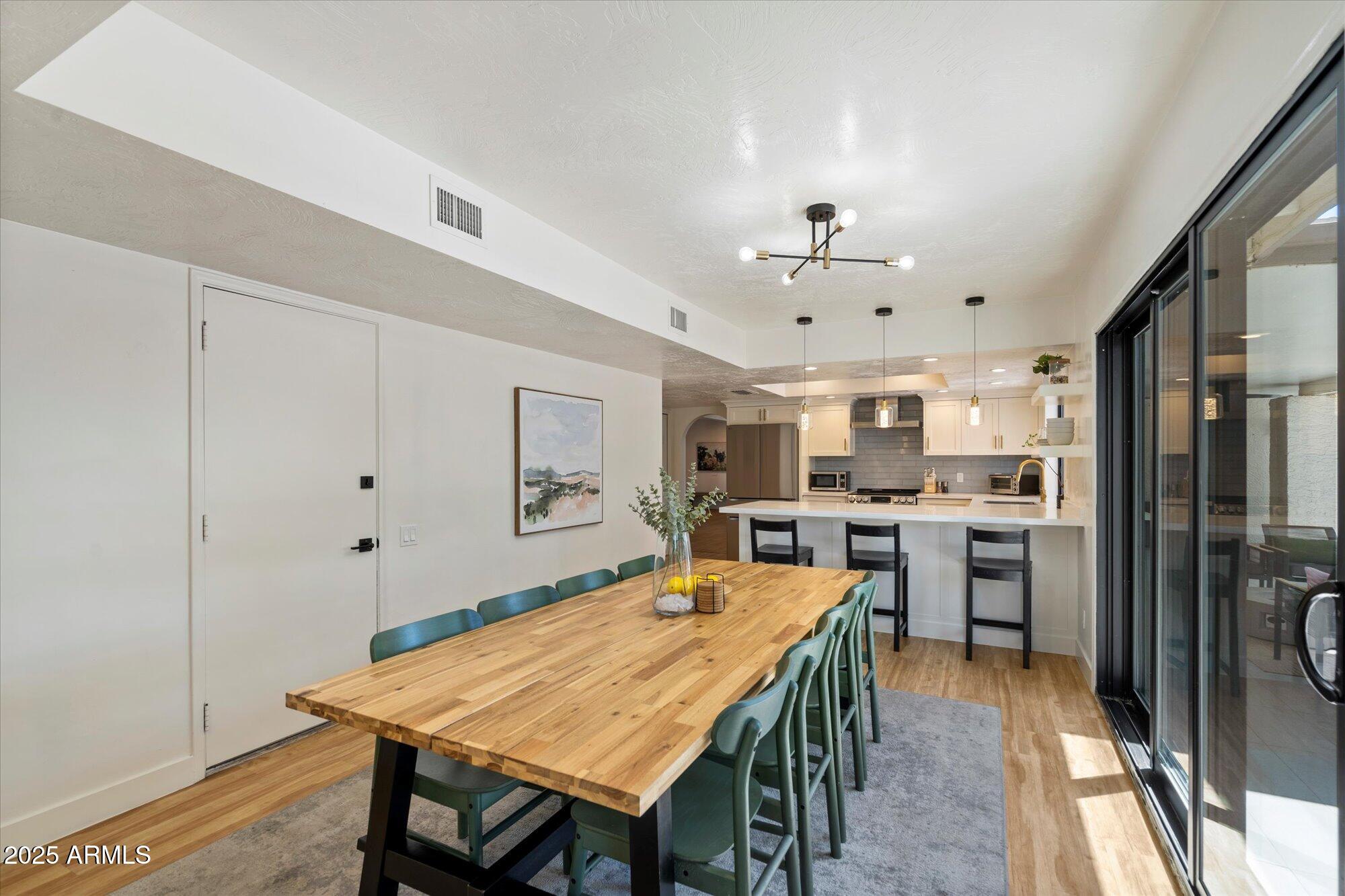 5701 East Charter Oak Road Scottsdale, AZ 85254 - Photo 10 of 27 a open kitchen with stainless steel appliances a dining table and chairs