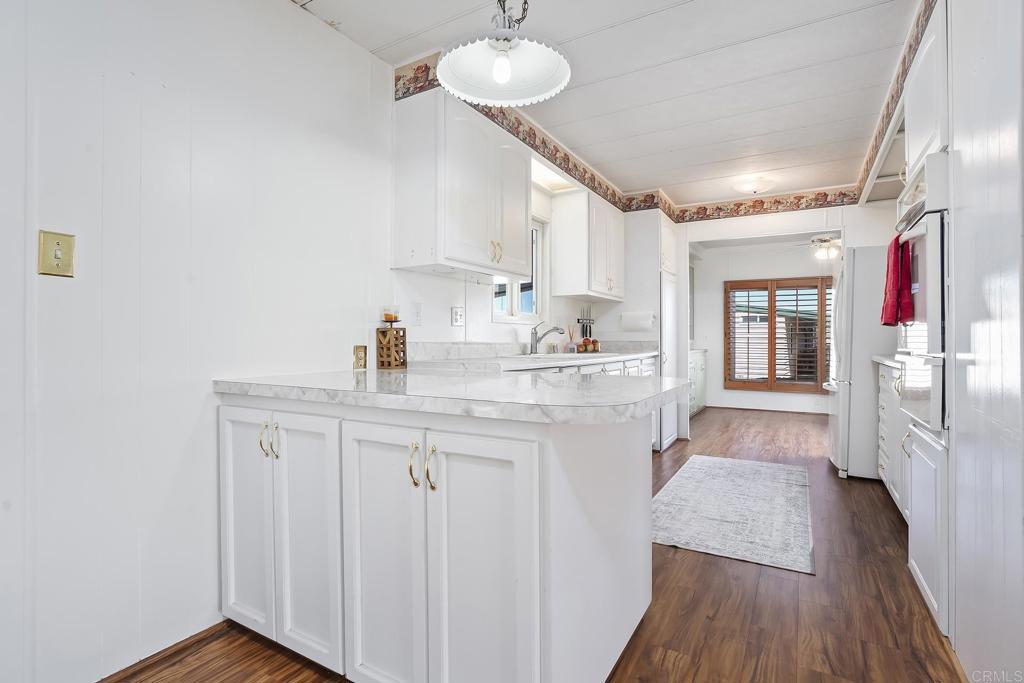 7467 Mission Gorge Road, Unit SPC 81 Santee, CA 92071 - Photo 7 of 36 a kitchen with stainless steel appliances granite countertop a sink cabinets and wooden floor