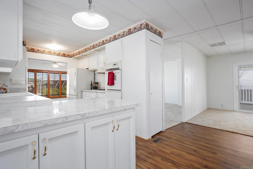 7467 Mission Gorge Road, Unit SPC 81 Santee, CA 92071 - Photo 8 of 36 a room with kitchen island a sink and wooden floor