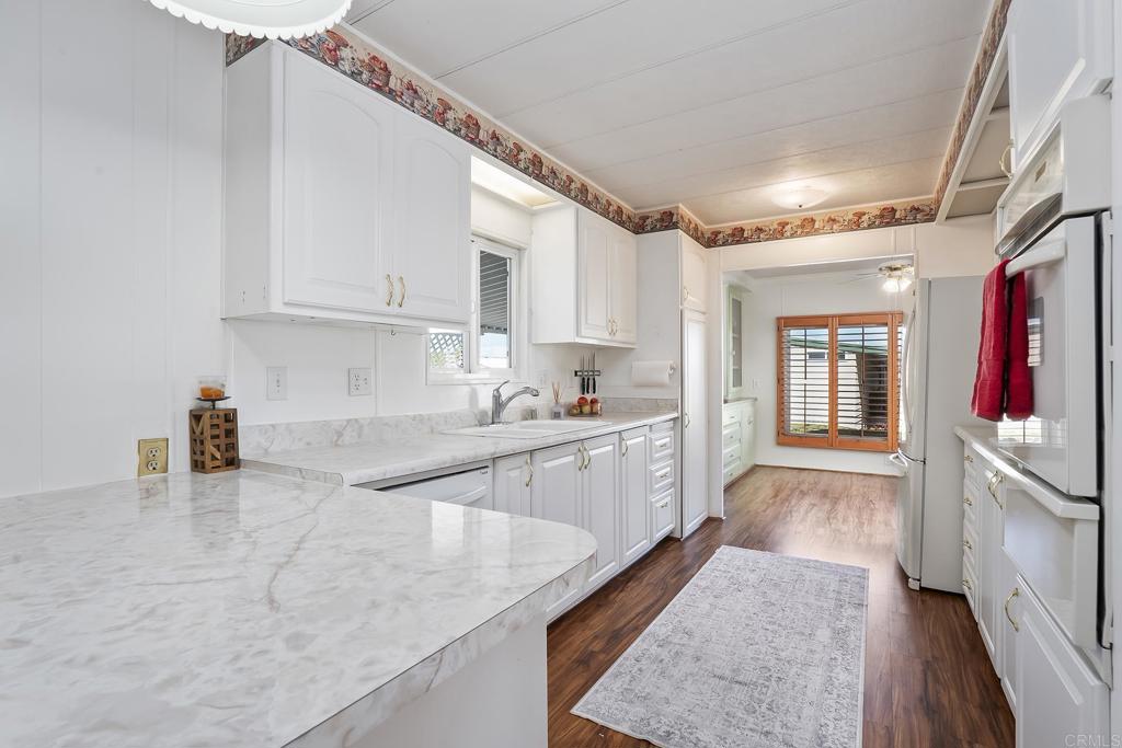 7467 Mission Gorge Road, Unit SPC 81 Santee, CA 92071 - Photo 9 of 36 a kitchen with granite countertop a sink stove and cabinets
