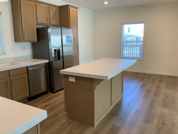 a kitchen with stainless steel appliances a kitchen island wooden floors and wooden cabinets