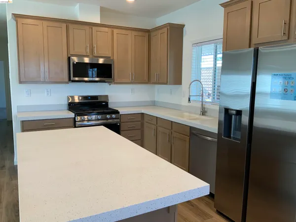 a kitchen with stainless steel appliances a microwave a sink and cabinets