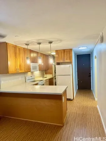 a kitchen with kitchen island wooden floors granite counter and stainless steel appliances