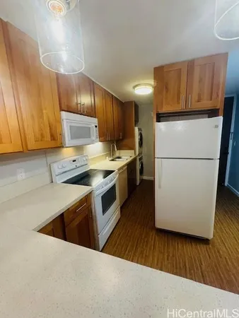 a kitchen with a refrigerator a stove top oven a sink and cabinets