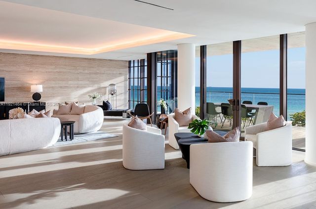 a living room with furniture and large windows