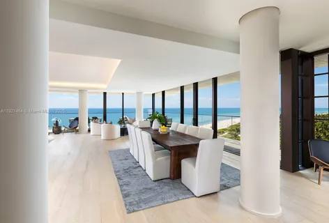 a living room with couches a coffee table and a large window with outer view