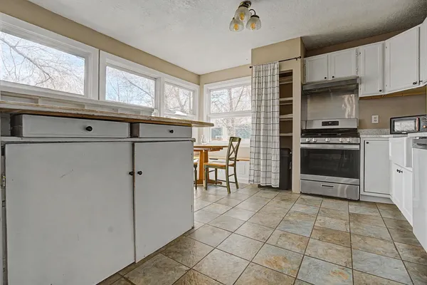 a kitchen with stainless steel appliances granite countertop a refrigerator and a stove top oven