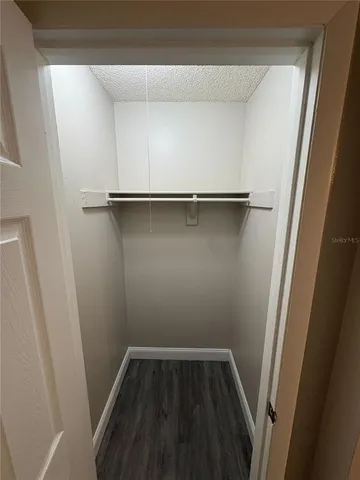 a view of walk in closet with wooden floor