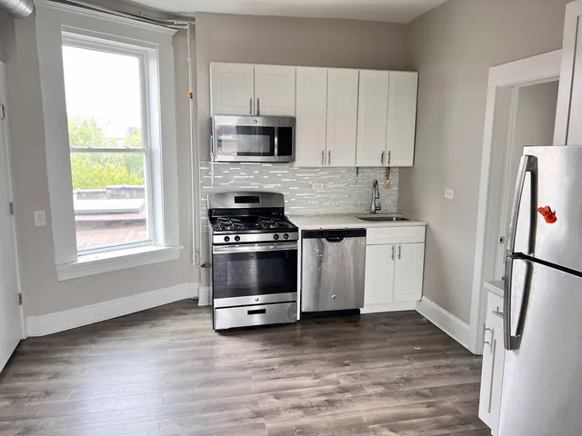 a kitchen with white cabinets and white appliances