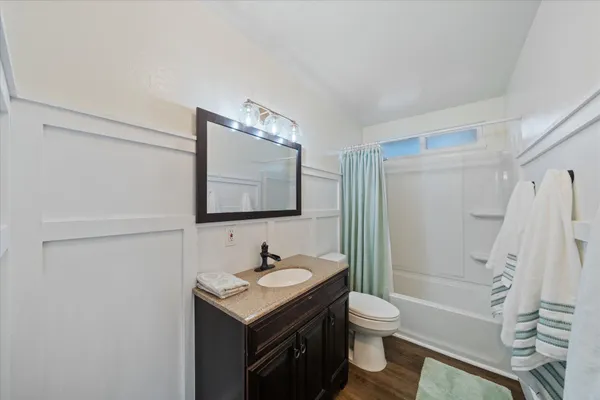a bathroom with a granite countertop sink toilet and shower