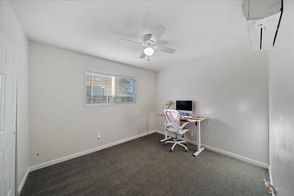a view of a workspace with furniture and a window