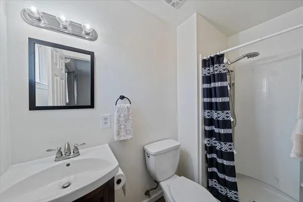 a bathroom with a toilet a sink and a mirror