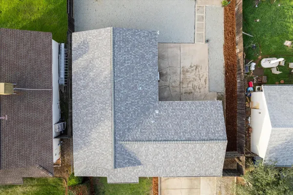 an aerial view of a house with outdoor space and seating area