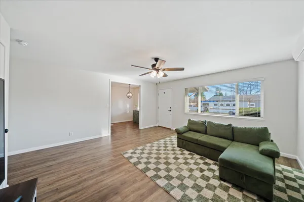 a living room with furniture and a ceiling fan