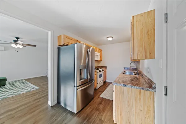 a kitchen with granite countertop a refrigerator and a sink