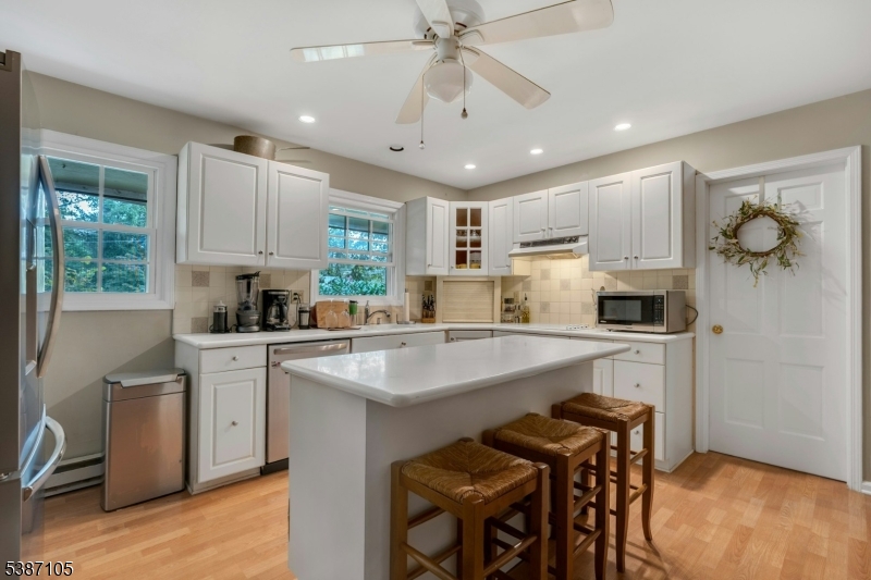 1 Crest Drive Bernards, NJ 07920 - Photo 9 of 21 a kitchen with a table chairs microwave and cabinets