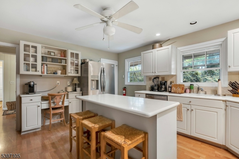 1 Crest Drive Bernards, NJ 07920 - Photo 10 of 21 a kitchen with stainless steel appliances granite countertop a stove top oven a sink a dining table and chairs with wooden floor