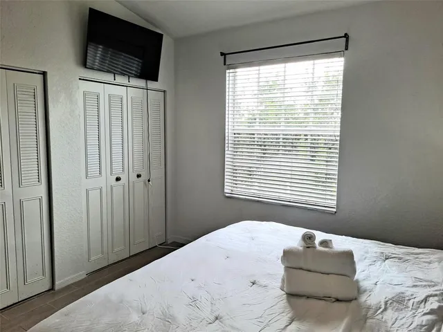 a bedroom with a bed and a flat screen tv